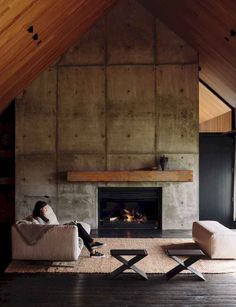 a woman sitting on a couch in front of a fire place