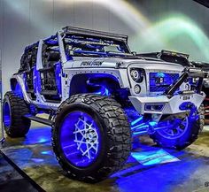 a white jeep with blue lights on it's front wheels and tire rims