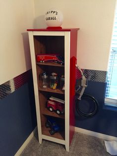 a toy firetruck is sitting on top of a bookcase in the corner of a room