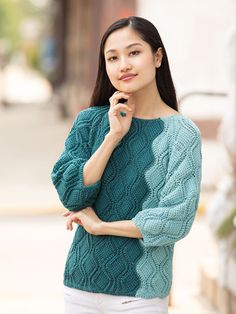 a woman standing in the street with her hand on her chin and looking off to the side