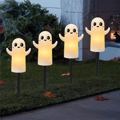 three white ghost lawn lights in the grass