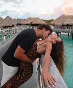 a man and woman kissing on the pier