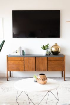 a flat screen tv mounted on the wall above a coffee table