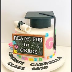 a graduation cake with a chalkboard and mortaron on top that says ready for 1st grade