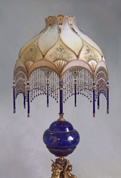 a blue and gold table lamp on a white background