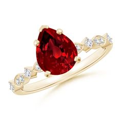 a ring with a large red stone and white diamonds on the side, set in yellow gold