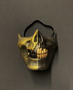 "This zombie half skull mask is hand painted in a brushed gold and solid black. Mask has unique style with raised detail and two-tone colors. Also, this mask is lightweight and has a foam backing and elastic band for a comfortable fit. Great addition to any Halloween zombie or skull style costume. Size 6.5\"W x 5.5\"H" Black Halloween Mask For Protection, Black Mask For Halloween Protection, Black Protective Mask For Halloween, Black Full Face Horror Mask, Black Horror Full Face Mask, Black Skull Mask For Halloween, Gold Halloween Costume Mask, Black Skull Shaped Mask For Masquerade, Black Skull Mask For Masquerade