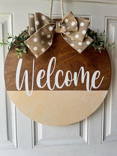 a welcome sign hanging on a door with polka dots and green leaves in the center