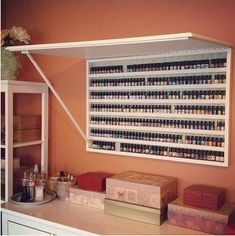 a shelf filled with lots of bottles on top of a counter next to a cabinet