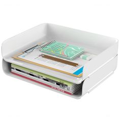 a stack of books in a white container on top of each other with papers and pencils