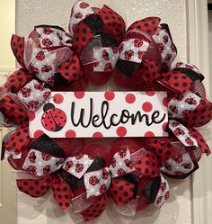 a ladybug wreath with the word welcome on it