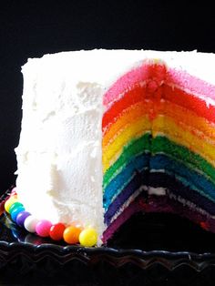 a rainbow cake with white frosting and colorful candies