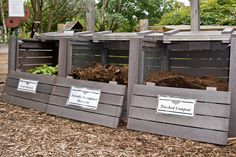 three bins filled with dirt sitting on top of a pile of wood mulch