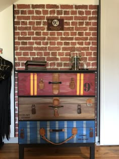 three suitcases stacked on top of each other in front of a brick wall