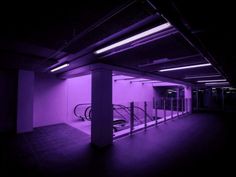 an empty parking garage with purple lighting