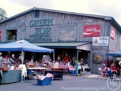 an outdoor market with people shopping and selling items