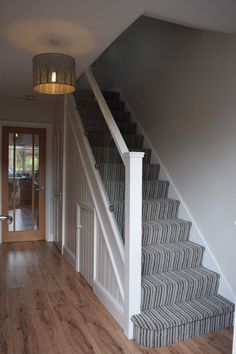 the stairs in this house are made of wood and have white railings on them