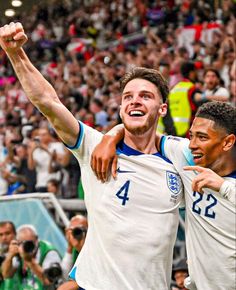 two soccer players are celebrating with their arms in the air