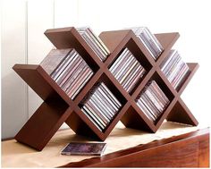 a wooden book shelf with many cd's in it on top of a table