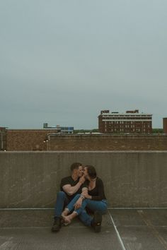 two people sitting on the ground kissing each other