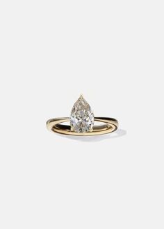 a yellow gold ring with a pear shaped diamond