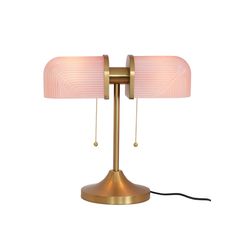 a gold table lamp with a pink shade on it's side and a black cord attached to the base