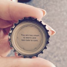 a person holding a bottle cap with a quote on the inside that says, you are too smart to worry and too cute to care