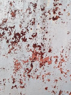 an old rusted metal surface with white and red paint