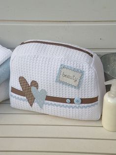 a white purse sitting on top of a bench next to a bottle of lotion