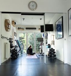 a woman is sitting on the floor in front of a mirror while doing yoga exercises