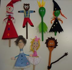 a group of paper dolls standing next to each other on top of a white surface