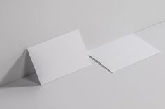 two pieces of paper sitting on top of each other next to an empty piece of paper