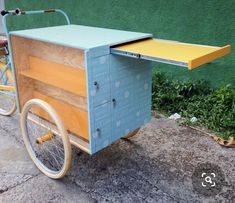 a blue and yellow cart sitting next to a green wall