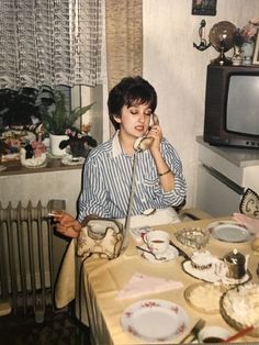 a man sitting at a table talking on a cell phone