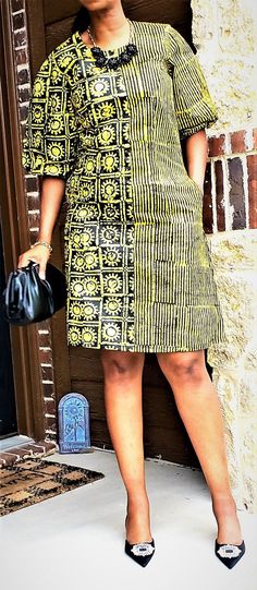 This lovely, A-Line dress in vibrant yellow and black will make you the life of any party ! The fabric is Nigerian Adiré which is hand-designed by local artisans in small batches using a wax-resist technique of fabric dyeing called batik.. This dress is lined and comes with pockets. NOTE: Color and pattern variations may exist due to the production process. Medium - Bust 38 inches Waist 34 inches Hips 40 inches Length (shoulder to hem) 40 inches Large - Bust 40 inches Waist 36 inches Hips 42 inc Yellow Batik Print Dresses, Black Short Sleeve Dress In Ankara Fabric, Black Short Sleeve Dress With Batik Print, Casual Black Dress With Batik Print, Womens Duster Coat, Print Formal Dress, Mode Batik, Styles Ankara, Blue Tie Dye Dress