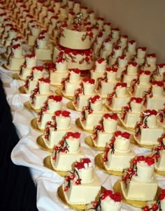 rows of wedding cakes with red bows on them