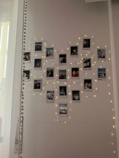 a white wall with many pictures on it and string lights strung across the entire wall