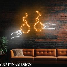 a couch sitting in front of a brick wall with a neon sign on the wall