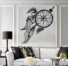 a living room filled with furniture and a wall mounted dream catcher on the side of it