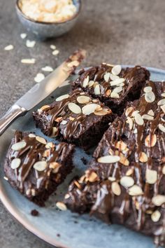 a plate topped with brownies covered in chocolate and almonds