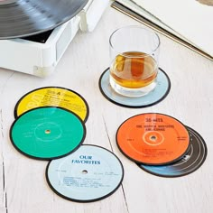 four records and a glass of alcohol on a table