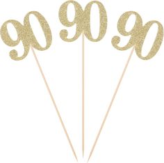 gold glitter 90th birthday cake toppers on sticks with the number 90 written in cursive font