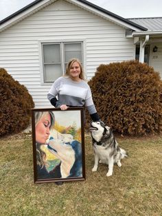 a woman standing next to a dog holding a painting