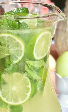 a pitcher filled with lemonade and lime slices