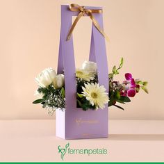 a purple bag with flowers in it sitting on a table