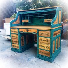 an old wooden desk is painted green and yellow with wood trimmings on it