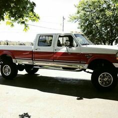 a red and white pickup truck parked on the street