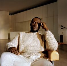 a man sitting in a chair talking on a cell phone