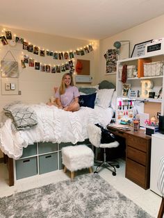 a woman sitting on top of a bed in a bedroom