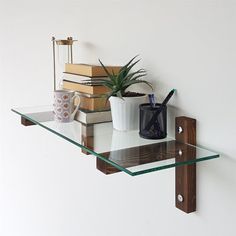 a glass shelf with books and plants on it